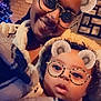 Djulïyan a rejoint le concours — aidez-le/la à gagner de superbes lots ! adult, baby, bear_ears, blanket, child, christmas_tree, cozy, curly_hair, cute, decor, expression, face, family, filter, glasses, home, indoor, portrait, smile, warm_lighting