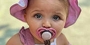 Inaya a rejoint le concours — aidez-le/la à gagner de superbes lots ! toddler, child, baby, pacifier, hat, pink, overalls, outdoor, portrait, cute, face, eyes, close_up, fashion, sunhat, summer, infant, person, young_child, accessory