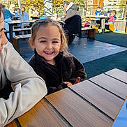 Aylan participe au concours pour gagner de l'argent avec cette photo : casual, child, daylight, face, friends, happy, jacket, nature, outdoor, park, people, relaxing, restaurant, sitting, smiling, sunny, table, trees, urban, wood