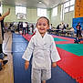 Aylan participe au concours pour gagner de l'argent avec cette photo : child, martial_arts, gi, barefoot, gymnasium, mat, smiling, people, indoors, sport, competition, audience, floor, young_child, training, happy, activity, event, person, judo