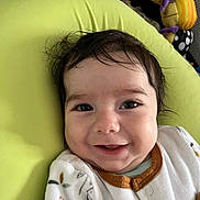 Matthieu participe au concours pour gagner de l'argent avec cette photo : baby, smile, face, infant, child, cushion, green, clothing, toy, happy, indoors, portrait, cozy, cute, young, sitting, head, eyes, skin, expression