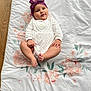 baby, infant, headband, purple, bow, blanket, floral_pattern, wooden_floor, white_clothing, cute, child, lying_down, soft_lighting, indoors, small_hands, small_feet, portrait, adorable, calm, looking_at_camera