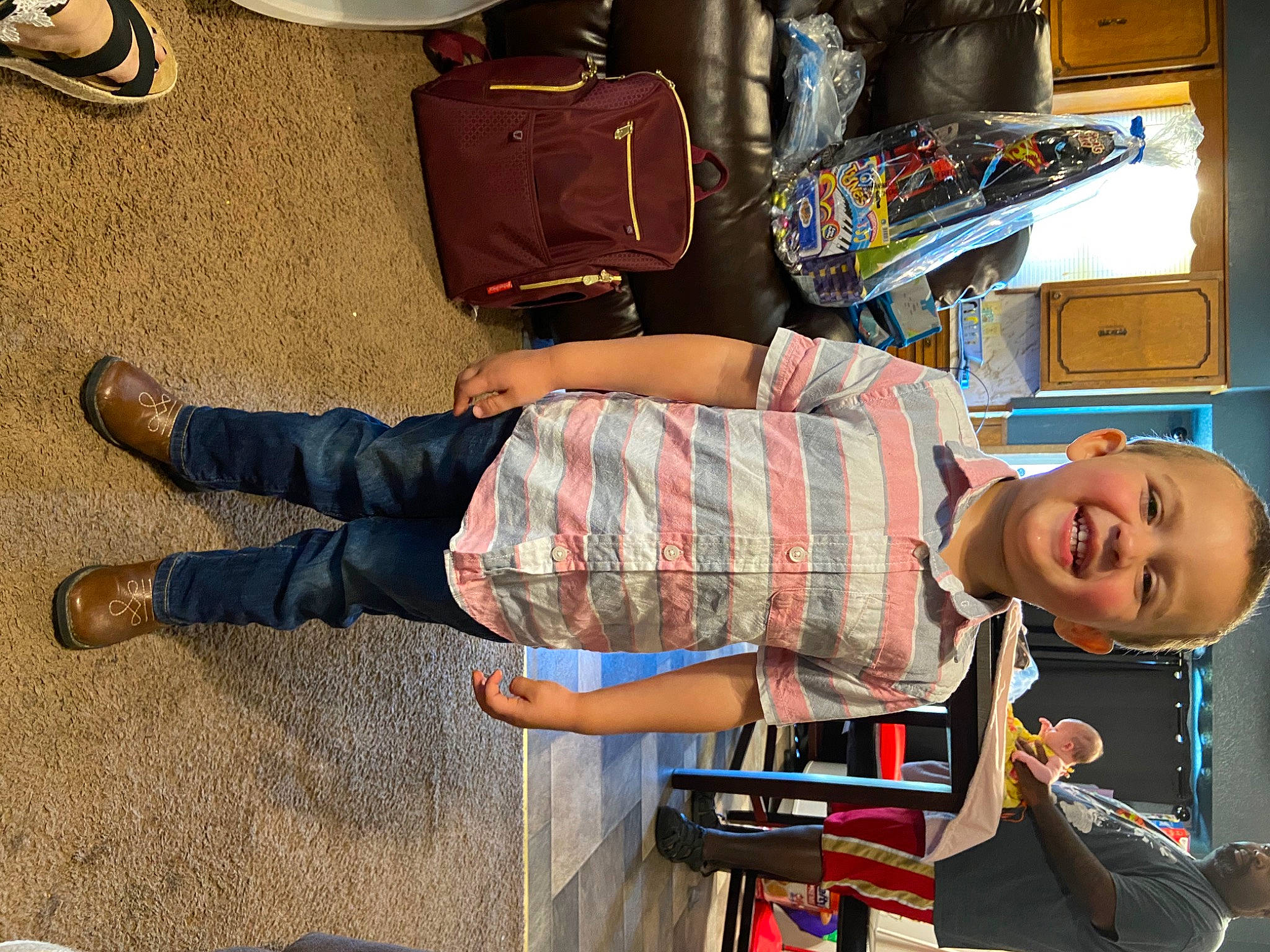 Keaton Swanson is registered to the contest to win money with this photo: bag, child, cool, flooring, foot, fun, hat, human_leg, joy, leg, luggage_and_bags, pattern, person, plaid, room, shorts, sitting, smile, t_shirt, thigh