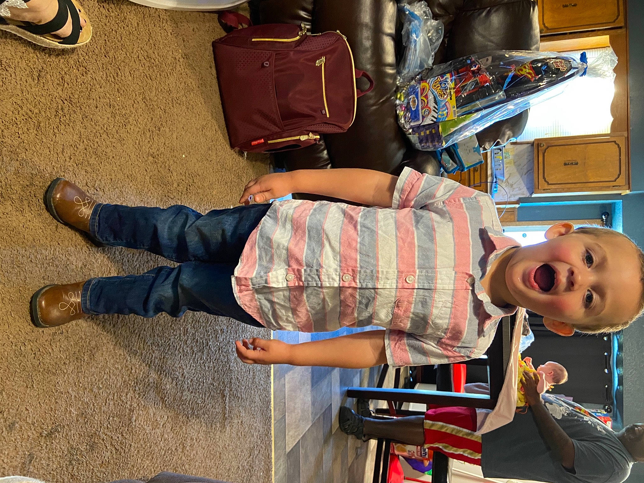 Keaton Swanson joined the competition — help win amazing prizes! backpack, bag, baggage, child, dress, flooring, foot, fun, human_leg, luggage_and_bags, pattern, person, room, sitting, street_fashion, t_shirt, textile, toddler, toy, travel