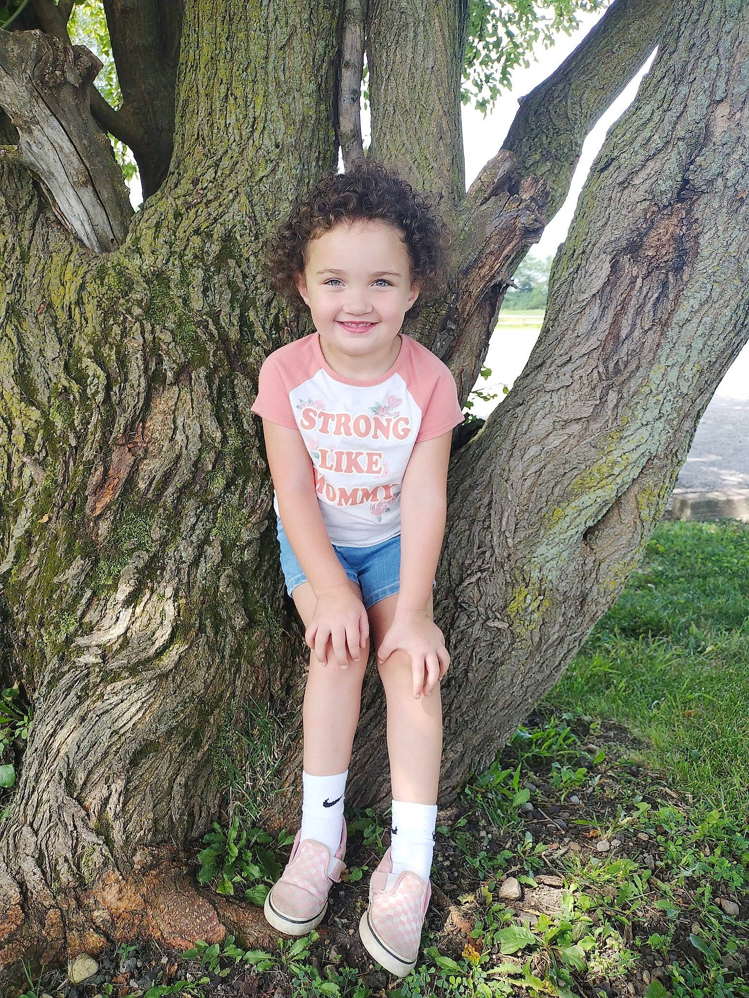 Annabella is registered to the contest to win money with this photo: electric_blue, flash_photography, foot, forest, grass, happy, human_leg, joy, knee, leisure, people_in_nature, person, plant, smile, t_shirt, thigh, toddler, tree, trunk, wood