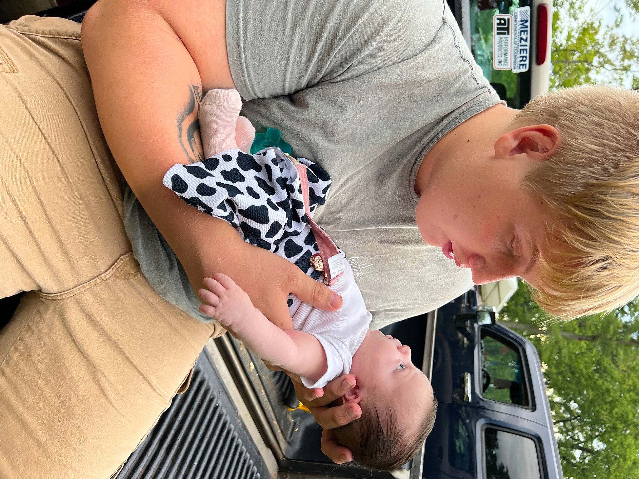 Oaklynn is registered to the contest to win money with this photo: arm, baby, child, comfort, elbow, eyewear, finger, gesture, glasses, grass, happy, human_leg, joint, nail, pattern, person, sitting, sunglasses, toddler, tree