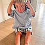 Louka participe au concours pour gagner de l'argent avec cette photo : barefoot, blue_eyes, casual_clothing, child, curious, cute, floor, headphones, indoor, light, person, playful, short_hair, sitting, smile, striped_shorts, toddler, tshirt, wooden_floor, young_child