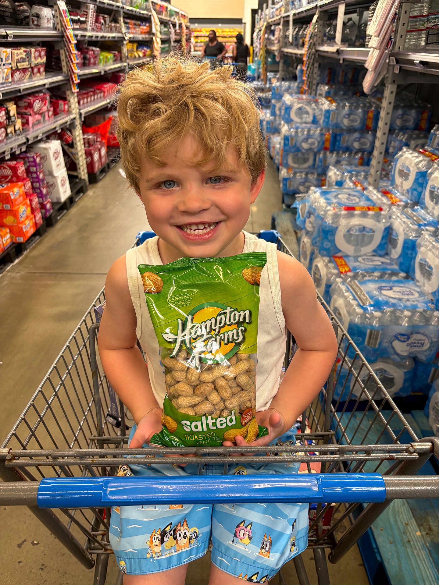 Flynn joined the competition — help win amazing prizes! child, boy, shopping_cart, store, grocery_store, snack, peanuts, bag, smiling, blonde_hair, shorts, aisle, products, water_bottles, retail, happy, casual_clothing, supermarket, indoor, shopping