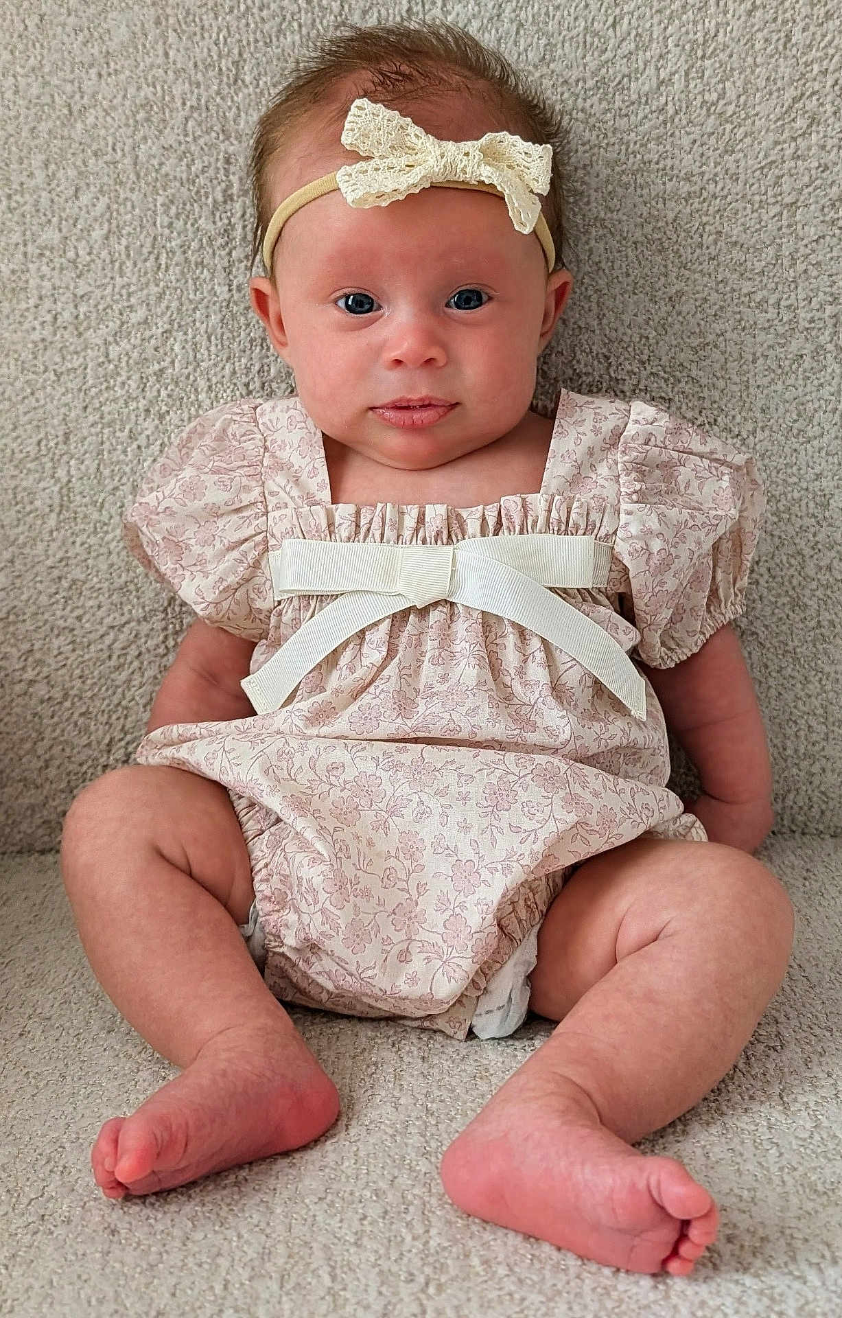 Elena joined the competition — help win amazing prizes! baby, infant, newborn, bow_headband, floral_dress, dress, clothing, sitting, carpet, feet, toes, legs, eyes, face, rosy_cheeks, portrait, closeup, cute, indoor, fabric