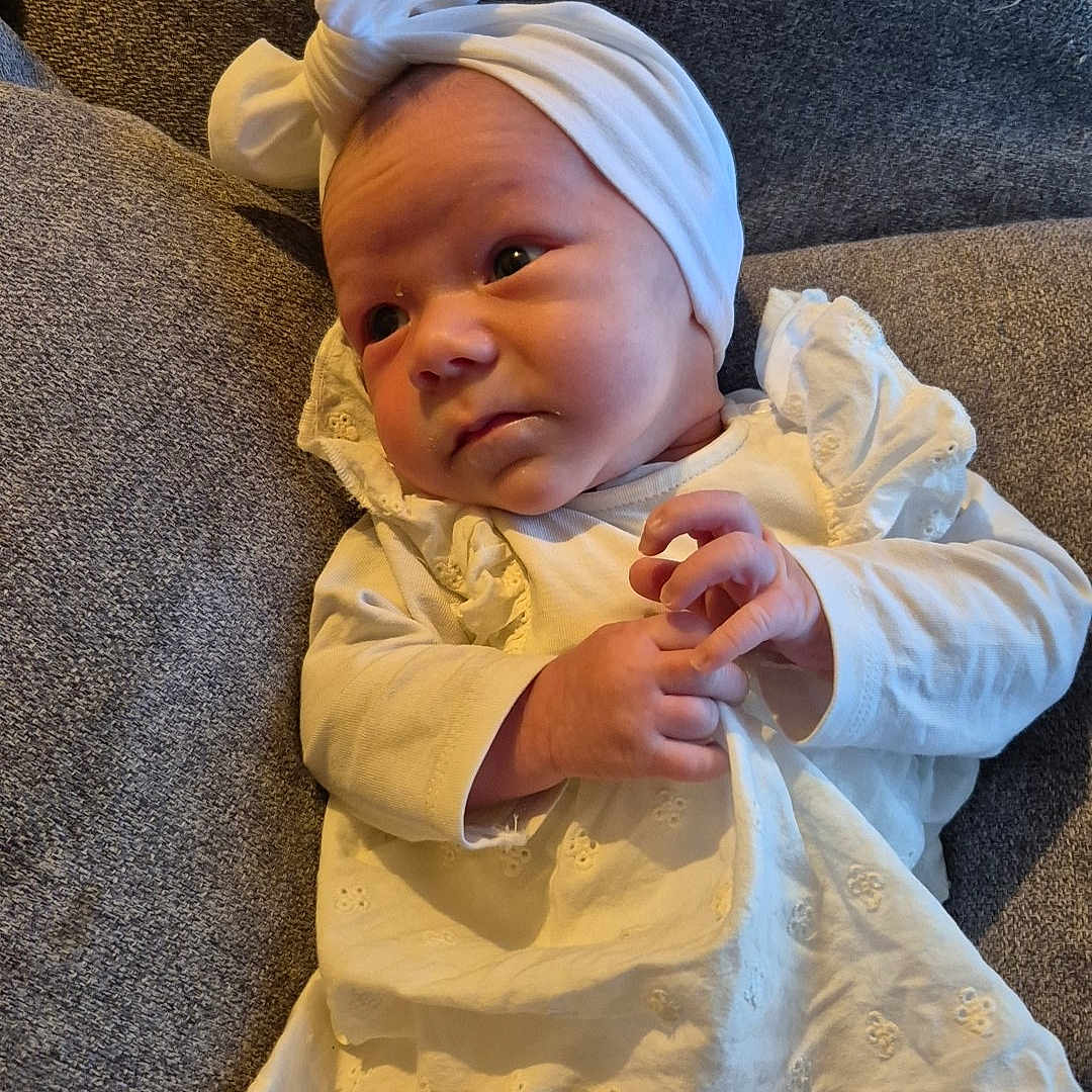 Julia participe au concours pour gagner de l'argent avec cette photo : baby, child, couch, cozy, curious, cute, expression, fabric, furniture, gray, head_wrap, indoors, infant, laying_down, newborn, peaceful, portrait, small_hands, soft_texture, white_clothing