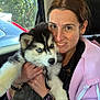 Leia is registered to the contest to win money with this photo: blue_eyes, bracelet, car_interior, closeup, cuddling, dog, fur, happy, husky, nature_outside, pet, pink_jacket, portrait, puppy, seat, smartwatch, smiling, sunlight, window, woman