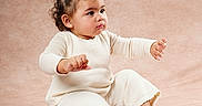 Everly joined the competition — help win amazing prizes! baby, child, cream_color, curly_hair, cute, earrings, expression, fashion, footwear, hair_accessory, indoor, knitwear, person, pink_shoes, portrait, sitting, soft_background, studio, toddler, young_child