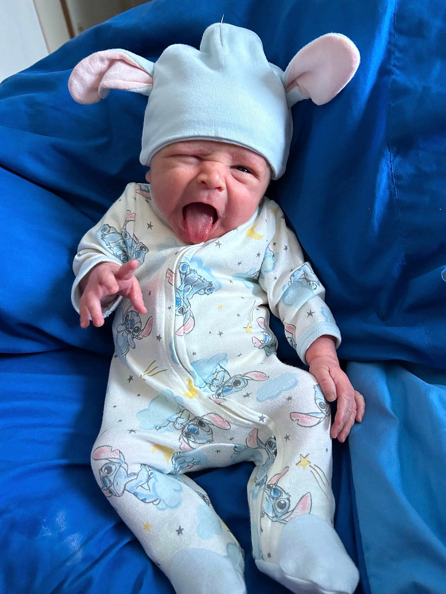 Cooper joined the competition — help win amazing prizes! baby, newborn, infant, hat, onesie, blue, blanket, cute, face, tongue_out, expression, child, clothing, lying_down, soft, comfy, funny_face, indoor, portrait, small_hands
