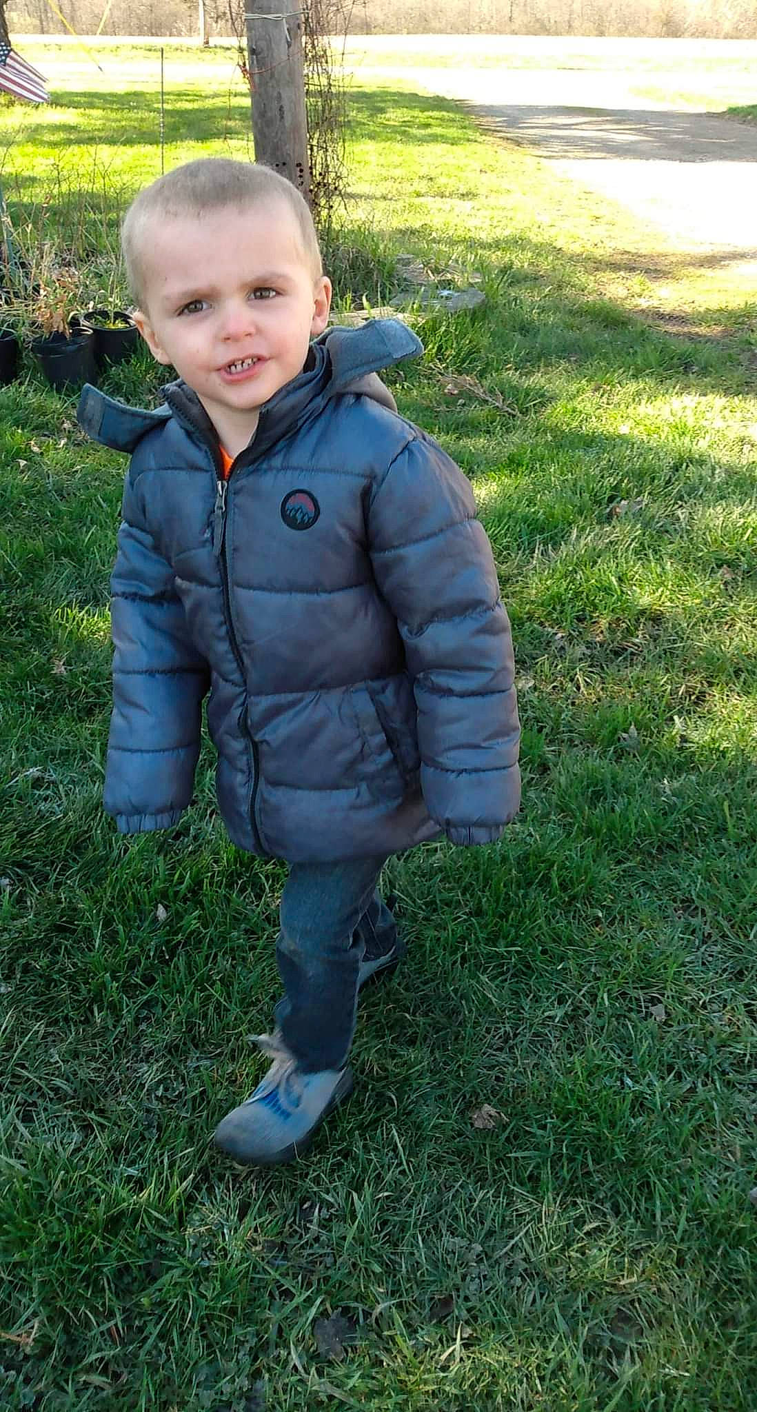 Jacob is registered to the contest to win money with this photo: baby, baby_toddler_clothing, electric_blue, eye, face, facial_expression, grass, grassland, happy, head, jacket, lawn, meadow, nose, people_in_nature, person, plant, sleeve, smile, toddler