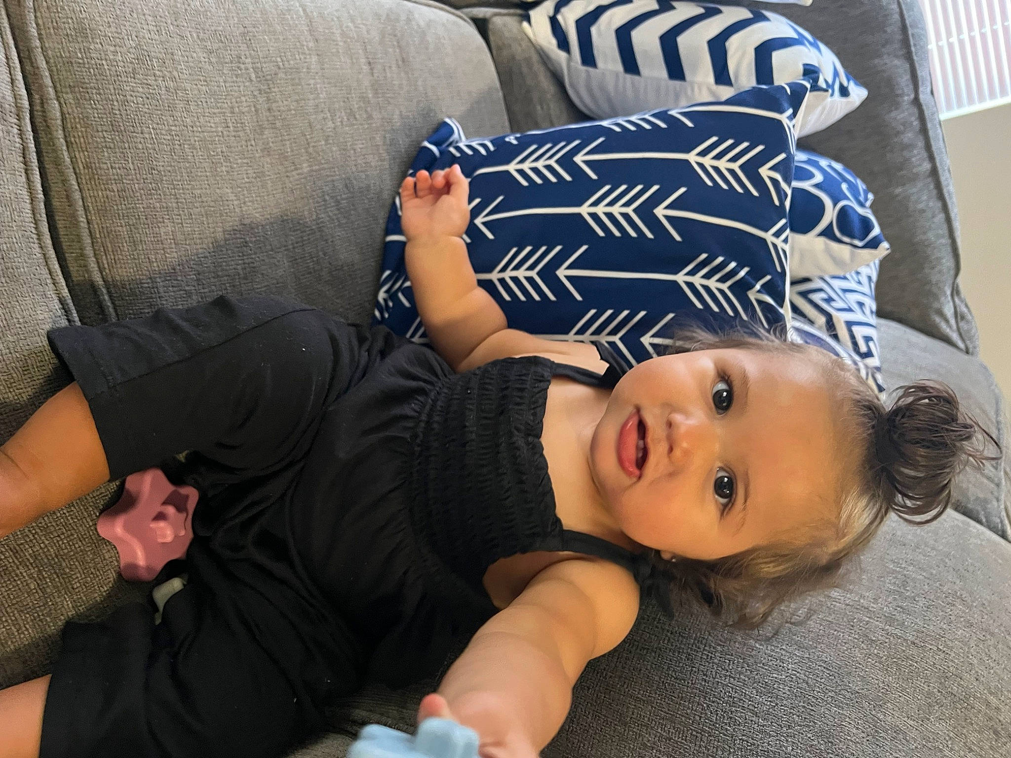 Dakota is registered to the contest to win money with this photo: arm, child, comfort, elbow, eye, flooring, fun, gesture, grass, hairstyle, happy, hat, human_leg, joint, knee, leg, person, sitting, smile, thigh