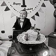 Amir participe au concours pour gagner de l'argent avec cette photo : baby, balloons, banner, birthday, black_and_white, bow_tie, cake, car, celebration, child, clothing, face, happy, indoor, luxury_toy, party_decor, portrait, smiling, toddler, toy_car
