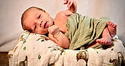 Daxton joined the competition — help win amazing prizes! baby, blanket, child, cute, face, green_cloth, indoors, infant, lying_down, newborn, patterned_blanket, peaceful, portrait, resting, skin, small_feet, small_hands, soft_lighting, wooden_surface, wrapped