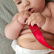 Luca joined the competition — help win amazing prizes! baby, infant, diaper, red_strap, hand, skin, face, curious, lying_down, soft_surface, chubby, cute, child, closeup, indoors, expression, chewing, rolls, person, young