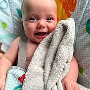 Ava joined the competition — help win amazing prizes! baby, towel, smile, happy, face, child, blanket, pattern, colorful, infant, cute, skin, hand, seatbelt, fabric, playful, closeup, portrait, indoor, soft