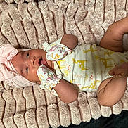 Jayleen is registered to the contest to win money with this photo: baby, infant, blanket, headwrap, mittens, onesie, giraffe_print, pink, yellow, cute, soft_texture, lying_down, child, newborn, happy, cozy, portrait, apparel, animal_print, indoor
