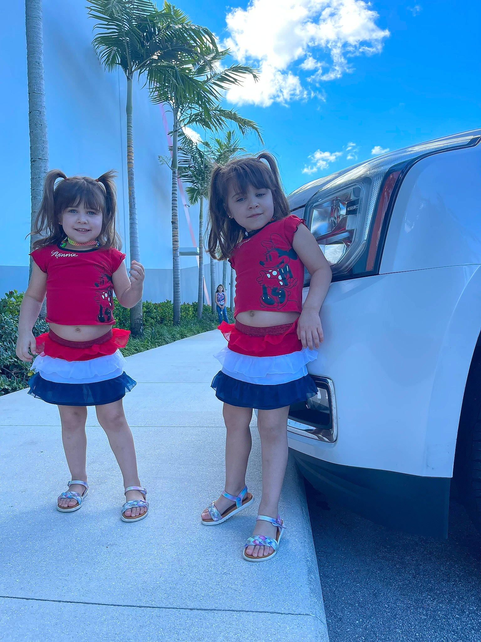 Valeria is registered to the contest to win money with this photo: automotive_lighting, automotive_tire, azure, blue, bumper, footwear, hood, joy, leg, leisure, motor_vehicle, person, shoe, sky, sneakers, standing, tire, toddler, tree, vehicle