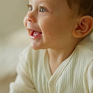 Manaël a rejoint le concours — aidez-le/la à gagner de superbes lots ! apparel, baby, child, close_up, clothing, cream_color, cute, ear, expression, eye, face, happy, indoor, infant, portrait, ribbed_fabric, side_profile, smiling, soft_light, young_child