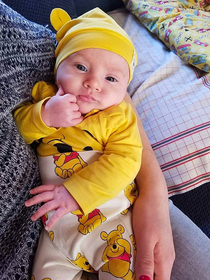 Julie is registered to the contest to win money with this photo: baby, baby_products, baby_toddler_clothing, child, headwear, person, product, skin, smile, textile, toddler, yellow