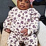 baby, child, infant, pink_hat, floral_outfit, socks, i_heart_mum, blanket, couch, soft_toy, indoor, person, resting, cute, cozy, hand, face, feet, clothing, home