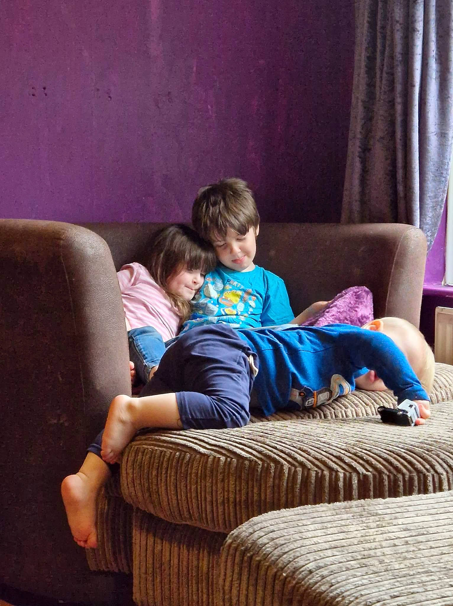 Samuel is registered to the contest to win money with this photo: arm, azure, comfort, couch, curtain, electronic_device, flooring, furniture, hairstyle, head, human_body, lap, leg, leisure, living_room, person, purple, studio_couch, textile, thigh