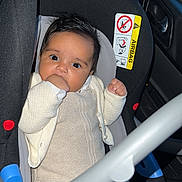 Djanna participe au concours pour gagner de l'argent avec cette photo : baby, car_seat, infant, child, seat_belt, car_interior, knit_clothing, hand, face, eyes, foot, sitting, safety, cute, indoors, person, car_door, window, black, white