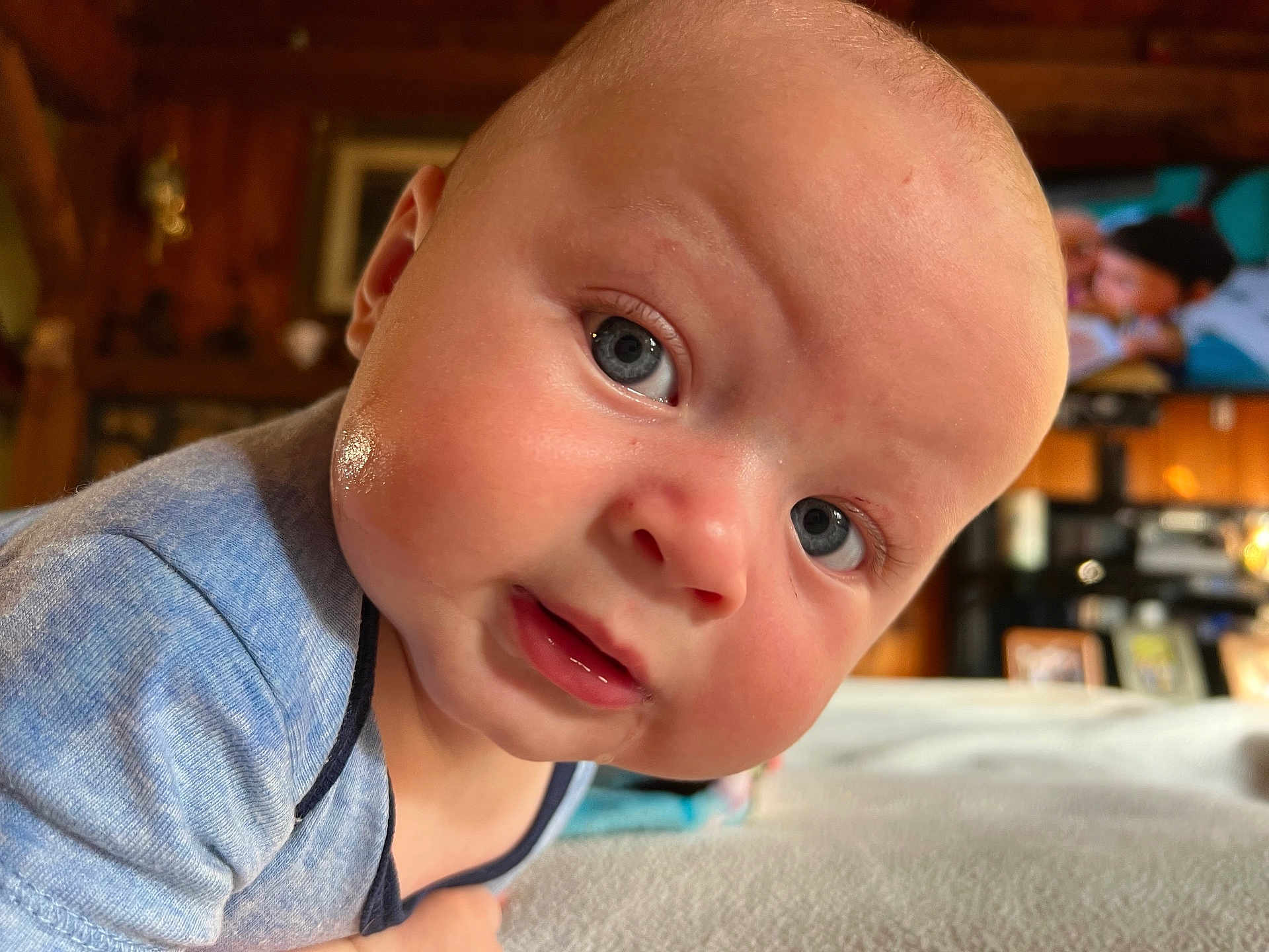 Bohdi is registered to the contest to win money with this photo: baby, close_up, face, blue_eyes, curious_expression, infant, indoor, soft_lighting, portrait, crawling, clothing, child, skin, head, person, young, cute, home, television, background