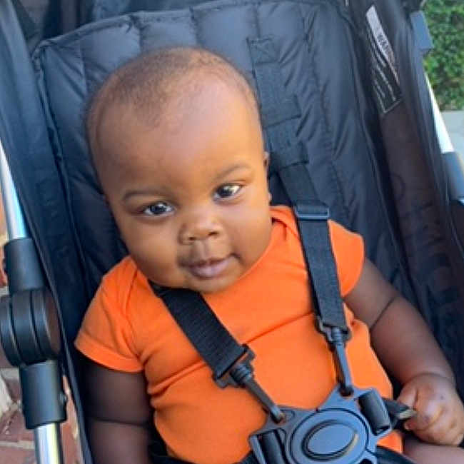 Dooda is registered to the contest to win money with this photo: accessories, baby, babylaughing, buggy, clothing, face, happy, head, lifejacket, person, photography, portrait, sitting, smile, strap, stroller, sunglasses, transportation, vehicle, vest