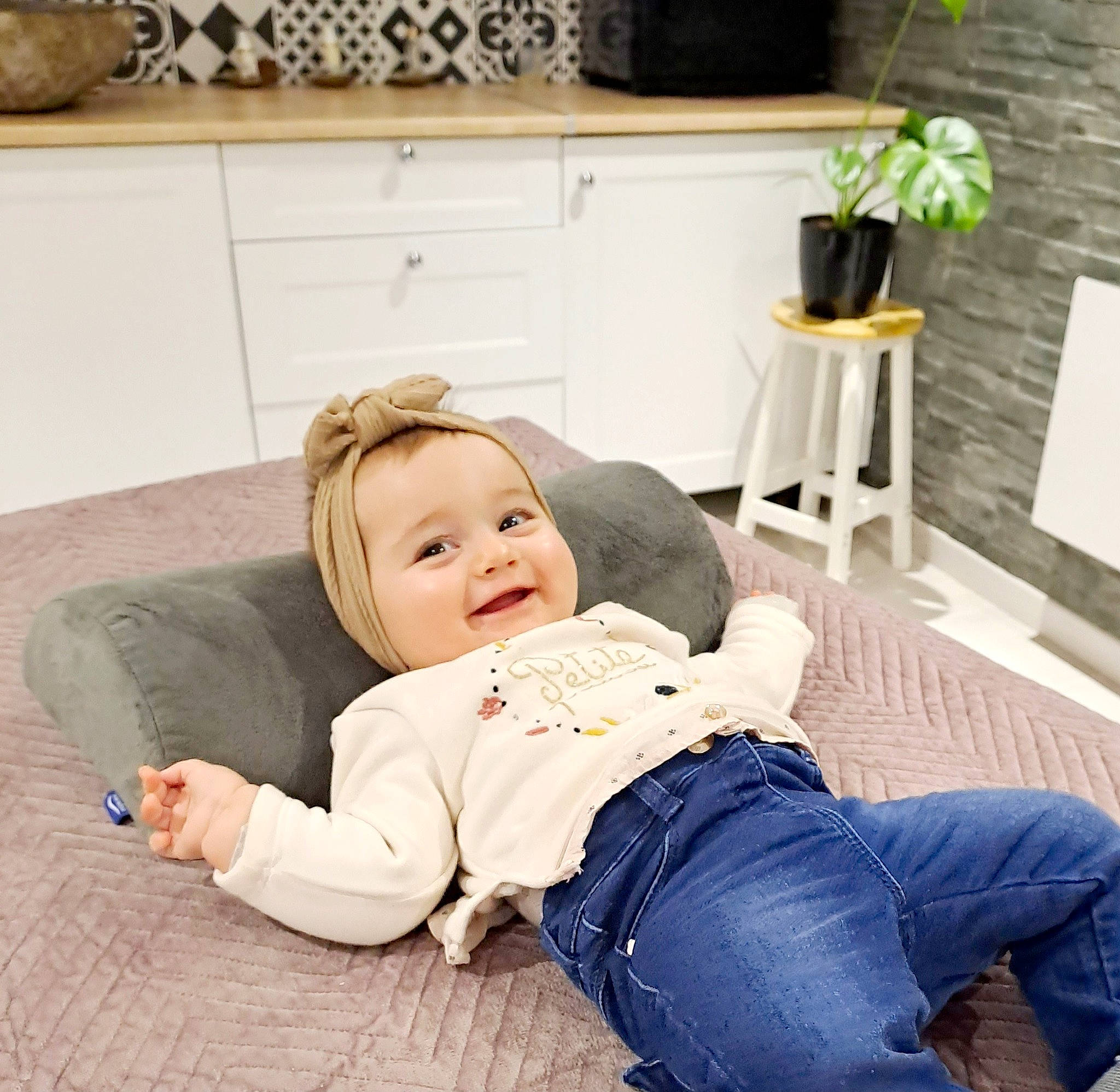 Camila participe au concours pour gagner de l'argent avec cette photo : child, comfort, couch, denim, flooring, foot, fun, happy, jeans, joy, knee, lap, leg, leisure, living_room, person, plant, room, sitting, smile