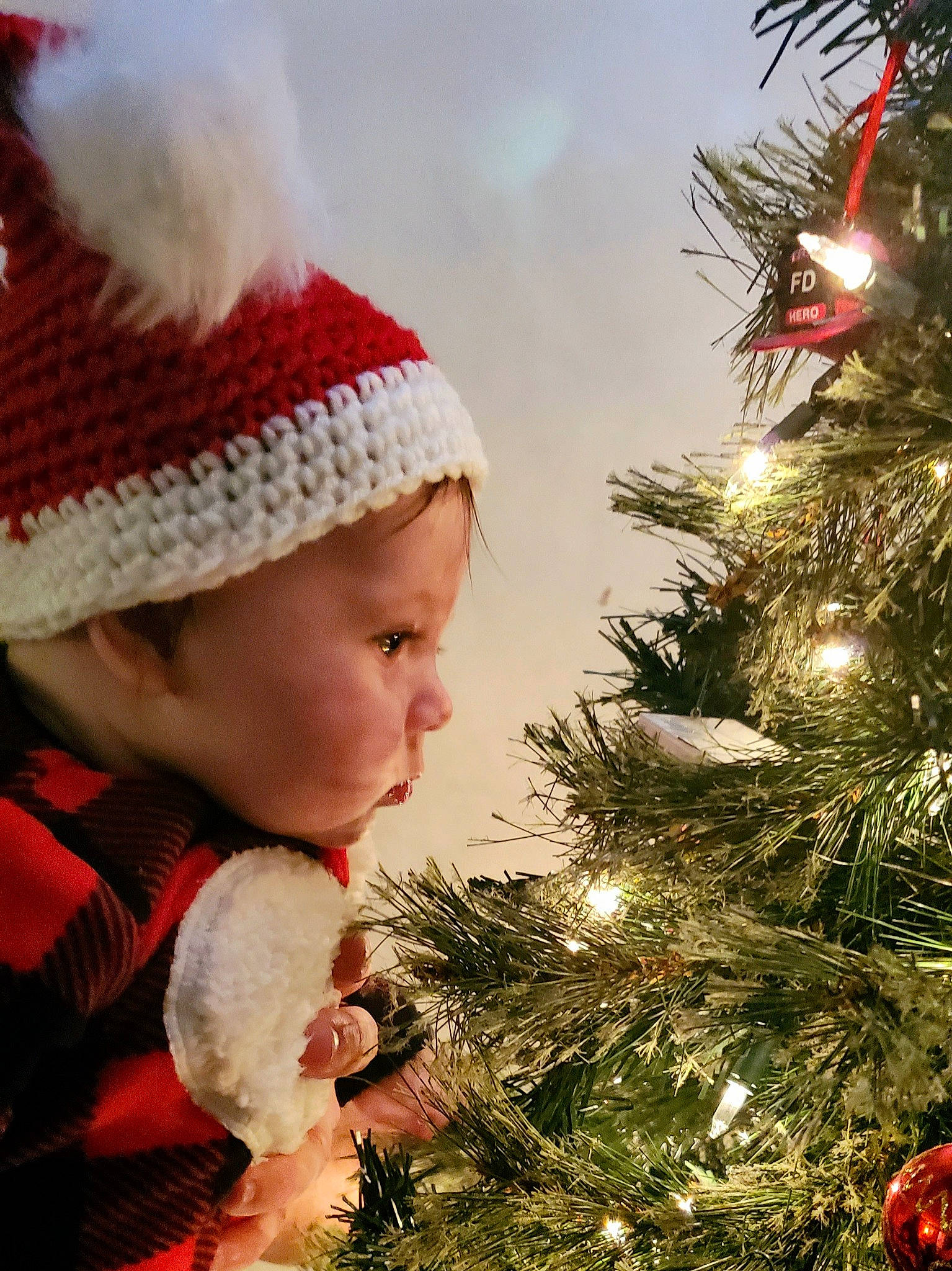 Ryleigh joined the competition — help win amazing prizes! bonnet, christmas, christmas_decoration, christmas_eve, christmas_lights, christmas_ornament, christmas_tree, event, evergreen, fur, headgear, holiday, holiday_ornament, human, interior_design, nose, person, red, toddler, tradition