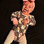 baby, infant, child, pink_bow, headband, onesie, floral_pattern, leopard_print, tongue_out, smiling, cute, lying_down, cozy, warm_clothing, tights, playful, adorable, happy, portrait, indoor