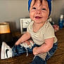 baby, blue_bow, headband, smiling, jeans, ripped_jeans, white_sneakers, nike, wooden_table, indoor, cute, child, happy, casual_clothing, portrait, sitting, person, infant, fashion, footwear
