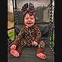baby, child, smiling, sitting, outdoor, chair, clothing, headwear, foot, cute, happy, fashion, pattern, brown, mesh, person, portrait, infant, one_person, accessory