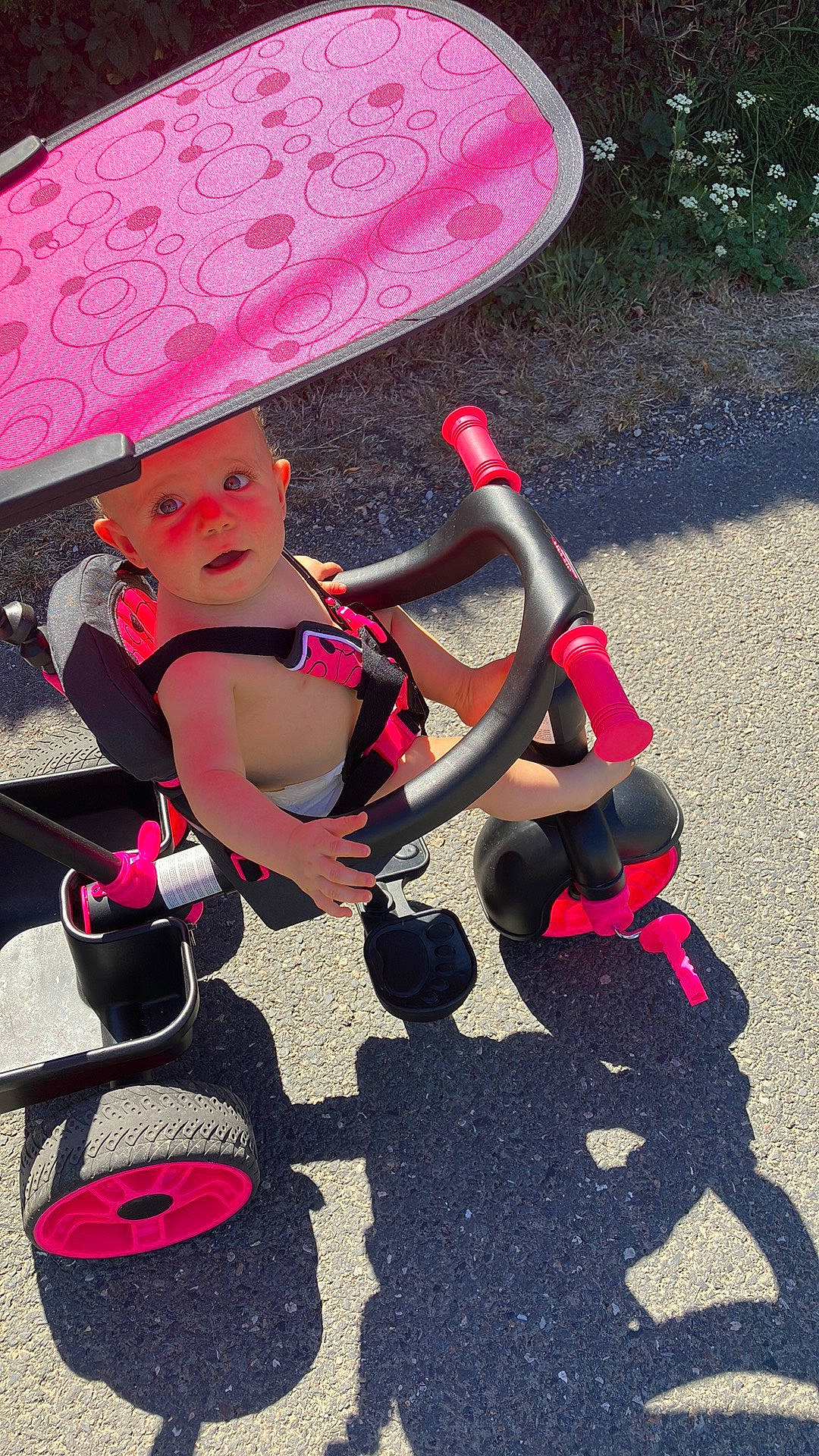 Maëly participe au concours pour gagner de l'argent avec cette photo : automotive_wheel_system, baby, baby_carriage, baby_products, carmine, costume, fun, hat, human_leg, leisure, magenta, pink, recreation, red, sidewalk, sitting, thigh, toddler, toy, wheel