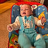 baby, infant, child, blue_outfit, baby_chair, animal_prints, cat, orange_cat, carpet, red_shoes, motion_blur, indoor, cute, playful, colorful, suspenders, bow_tie, person, furniture, floor