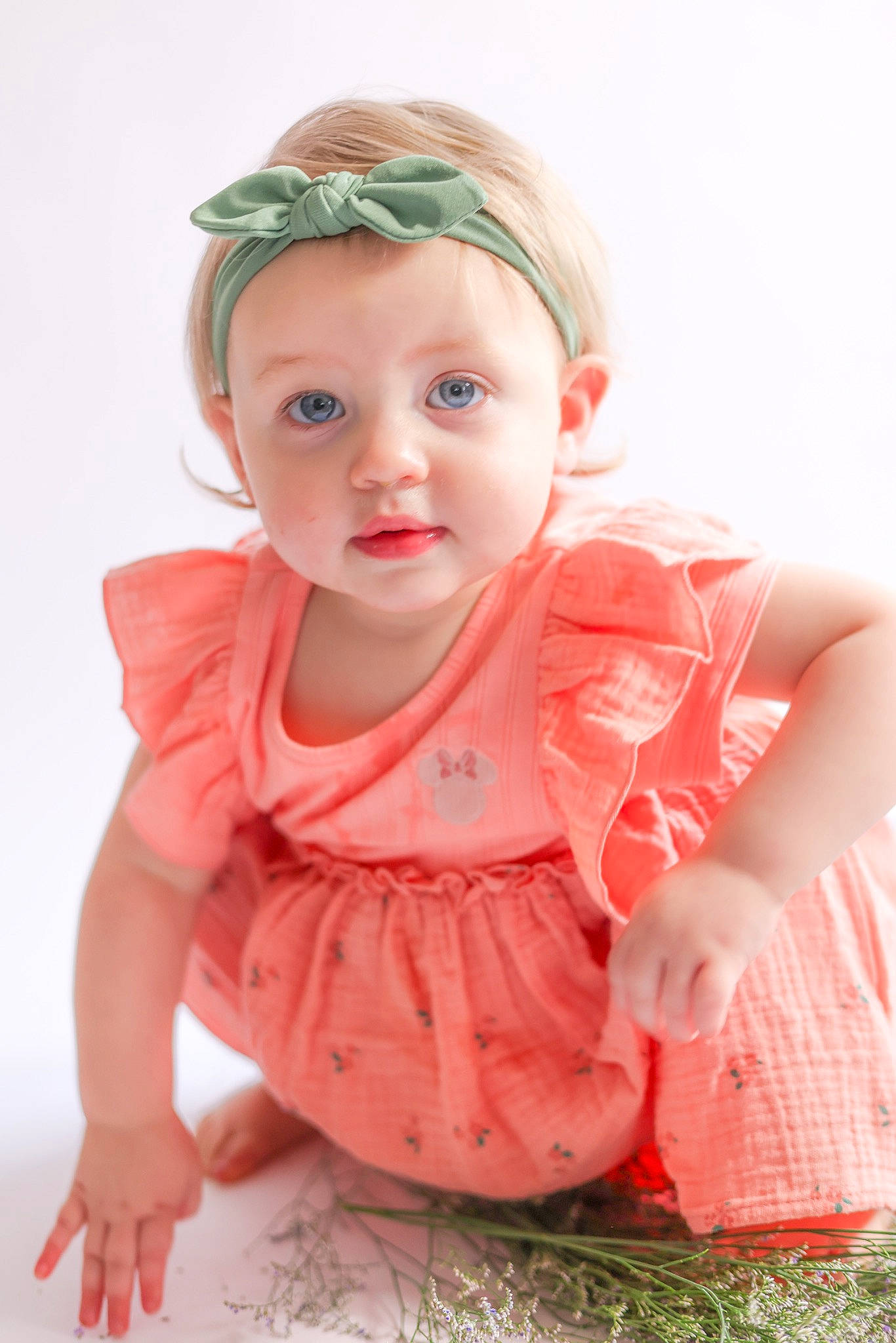 Finley is registered to the contest to win money with this photo: arm, baby, baby_toddler_clothing, cap, cheek, child, day_dress, dress, eyelash, fashion_accessory, hand, happy, lip, pattern, peach, person, pink, sitting, skin, sleeve