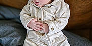 Jules participe au concours pour gagner de l'argent avec cette photo : baby, blanket, blue_eyes, child, clothing, corduroy, cozy, cute, expression, fabric, face, hands, indoors, infant, pajamas, person, portrait, sitting, soft_lighting, texture