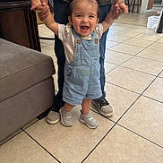 Gianna joined the competition — help win amazing prizes! toddler, child, indoor, happy, smiling, walking, holding_hands, person, jeans, sneakers, overalls, tile_floor, furniture, sofa, home, hair_ties, playful, support, family, cute