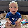 Copeland joined the competition — help win amazing prizes! baby, smiling, blue_shirt, sitting, toy, couch, indoor, happy, child, diaper, playmat, cute, infant, person, face, hands, feet, colorful, plush_toy, home