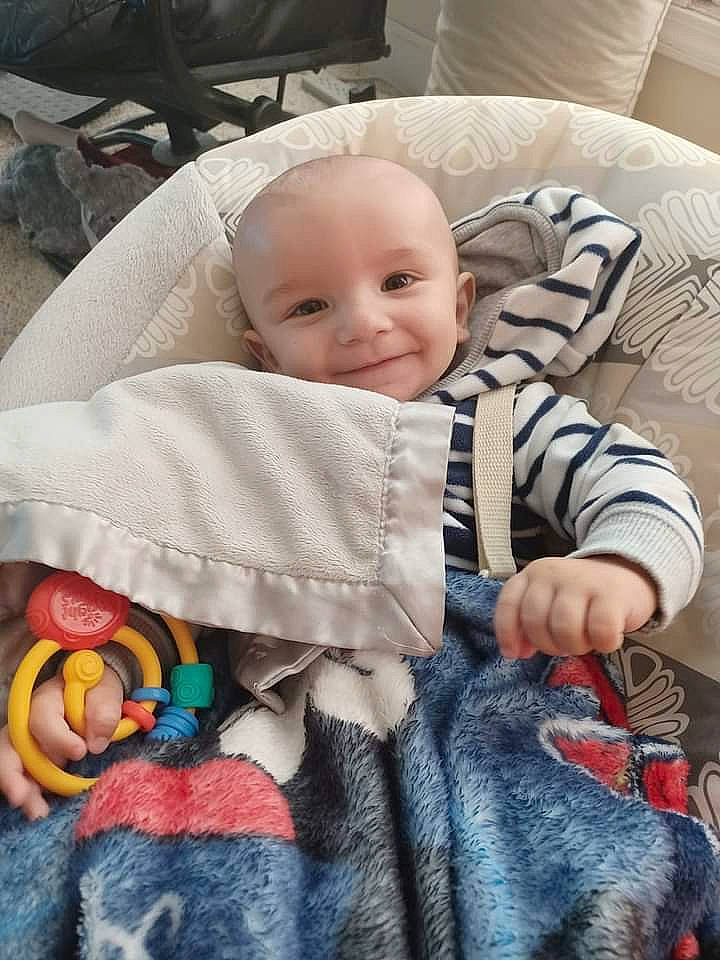 Drew is registered to the contest to win money with this photo: baby, baby_toddler_clothing, cheek, child, comfort, eye, face, facial_expression, head, iris, joy, linens, organ, people, person, skin, sleeve, smile, snapshot, textile