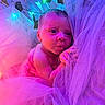 baby, infant, tulle, fabric, pink, purple, lights, fairy_lights, leaves, curious, portrait, face, newborn, soft_texture, glowing, cute, child, closeup, wrapped, resting