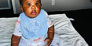 Jamal is registered to the contest to win money with this photo: baby, boy, infant, child, blue_bib, sitting, toys, blanket, indoors, curious, clothing, socks, cute, face, expression, playtime, soft_texture, colorful, young, portrait