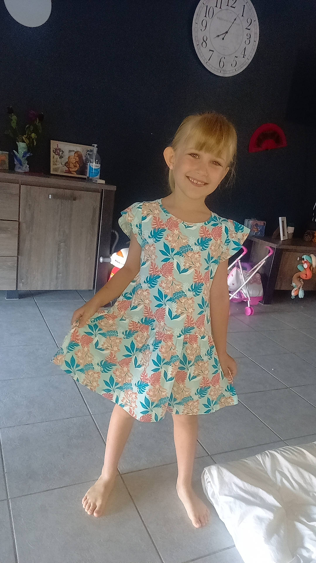 Leyana participe au concours pour gagner de l'argent avec cette photo : cabinetry, child, day_dress, dress, electric_blue, entertainment, event, fashion_design, flooring, houseplant, human_leg, joint, joy, one_piece_garment, person, sandal, shoulder, sleeve, smile, thigh