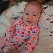 Yahmiyeh joined the competition — help win amazing prizes! baby, child, pajamas, smile, face, hand, bed, pillow, pattern, colorful, infant, person, cute, cozy, indoor, sleepwear, holding_hand, happy, portrait, young