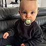 Maëlan participe au concours pour gagner de l'argent avec cette photo : baby, biting, bodypart, clothing, couch, eating, face, finger, food, furniture, hand, head, knitwear, person, photography, portrait, sitting, sweater