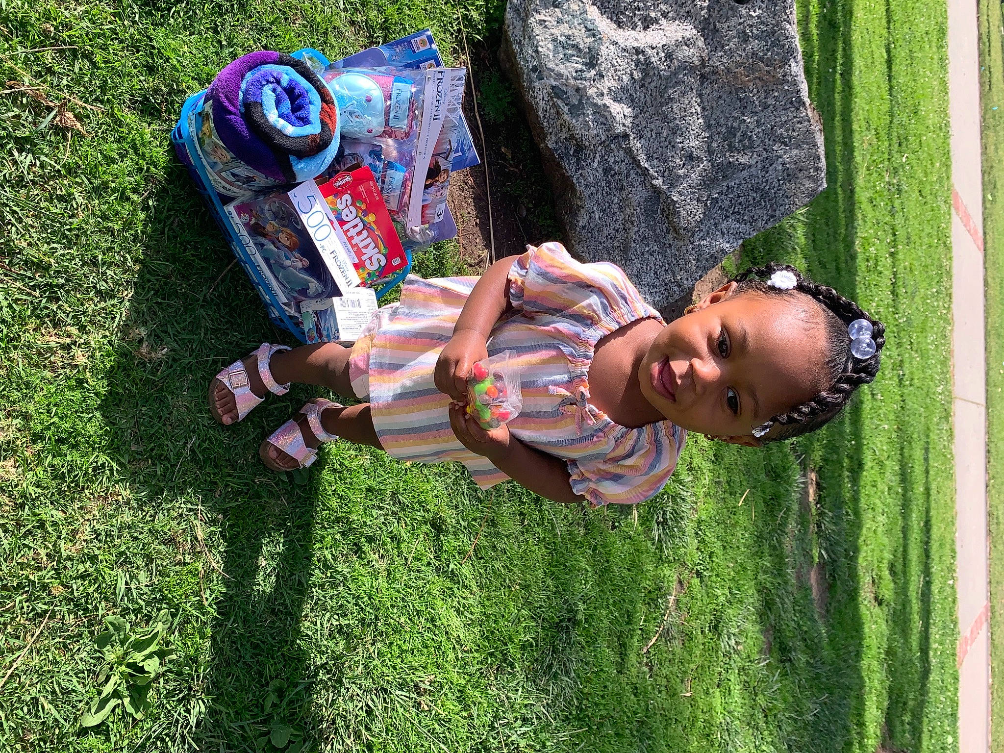 Taylor is registered to the contest to win money with this photo: book, child, cool, eyewear, fun, grass, grass_family, grassland, green, happy, hat, landscape, lawn, leisure, people_in_nature, person, plant, recreation, smile, toddler